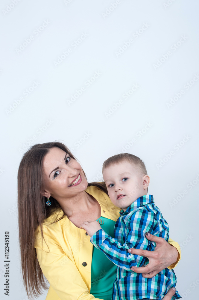 Boy in shirt sitting with mom on light background Boy in shirt sitting with mom on light background