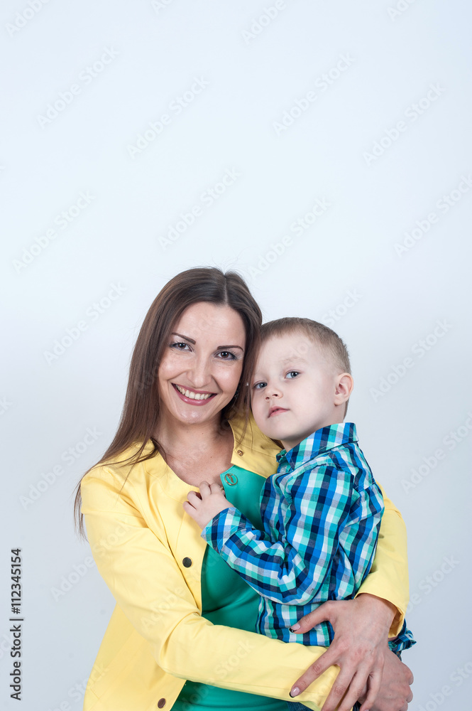 Boy in shirt sitting with mom on light background Boy in shirt sitting with mom on light background