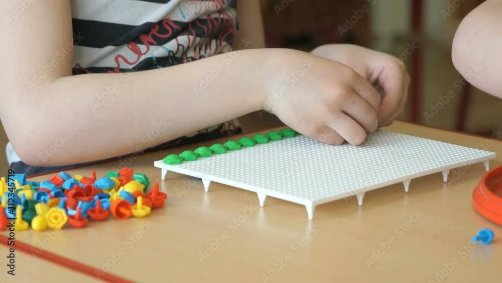 Little child plays a intellectual game at a table Little child plays a intellectual game at a table