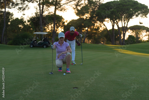 couple on golf course at sunset