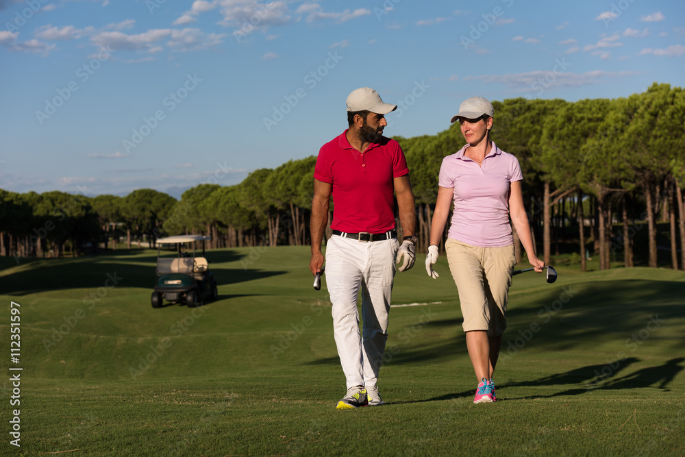 couple walking on golf course couple walking on golf course