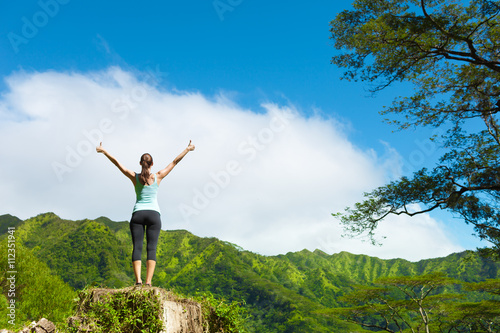 Fit female feeling free in a green nature setting.