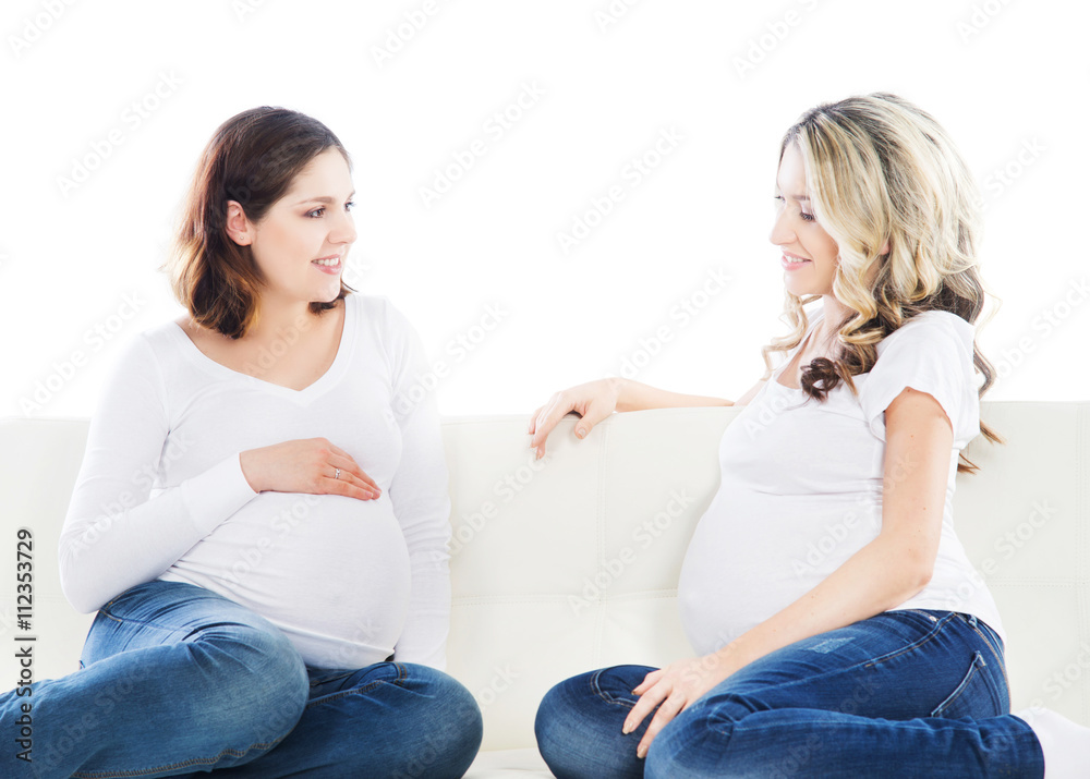 Two attractive expectant mothers chatting with each other Two attractive expectant mothers chatting with each other