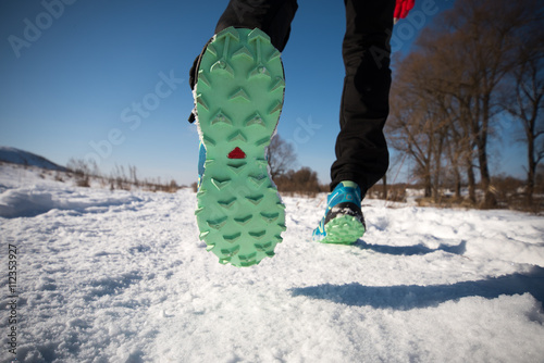 Running shoes close up. Legs runner closeup. Trail running on a snow-covered winter trail. Motivation concept