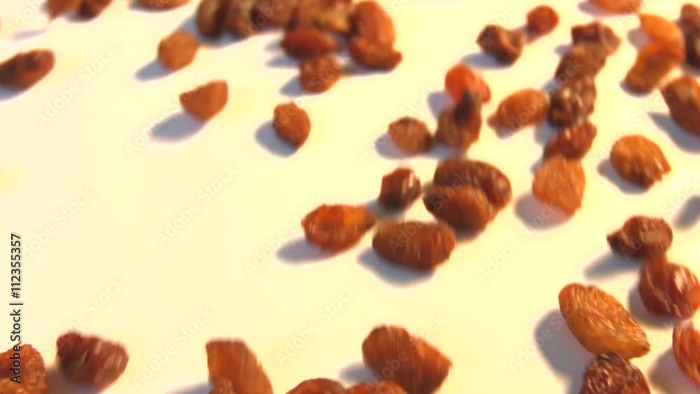 Raisins on a white background. 2 Shots. Horizontal pan. Close-up. Slow motion. Raisins on a white background. 2 Shots. Horizontal pan. Close-up. Slow motion.