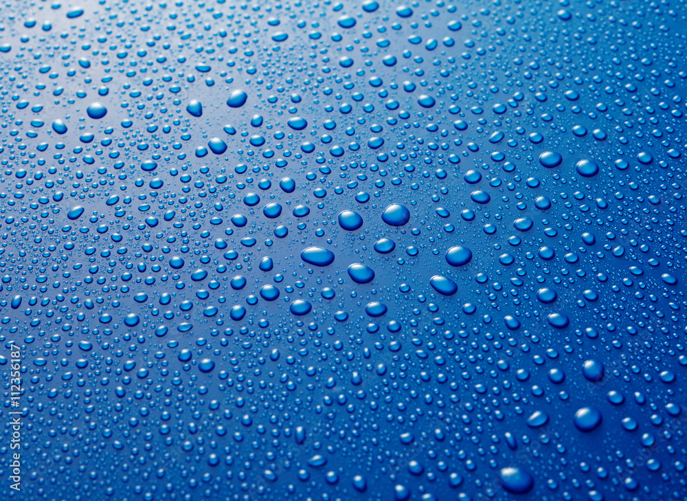 Water drops beaded on blue metallic surface