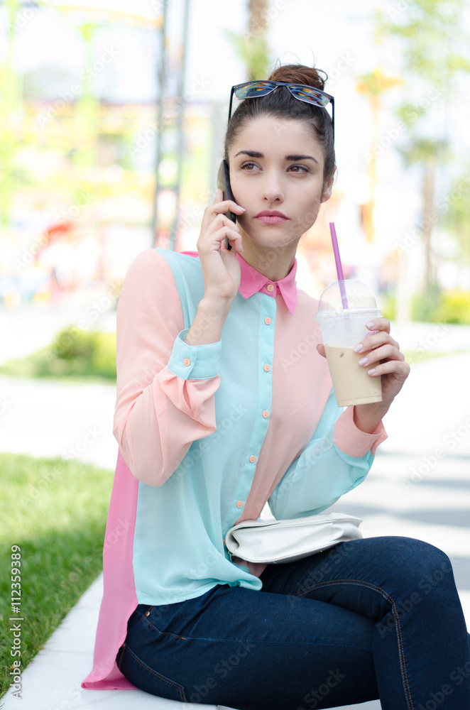 Pretty girl speaking by smart phone with iced latte Pretty girl speaking by smart phone with iced latte