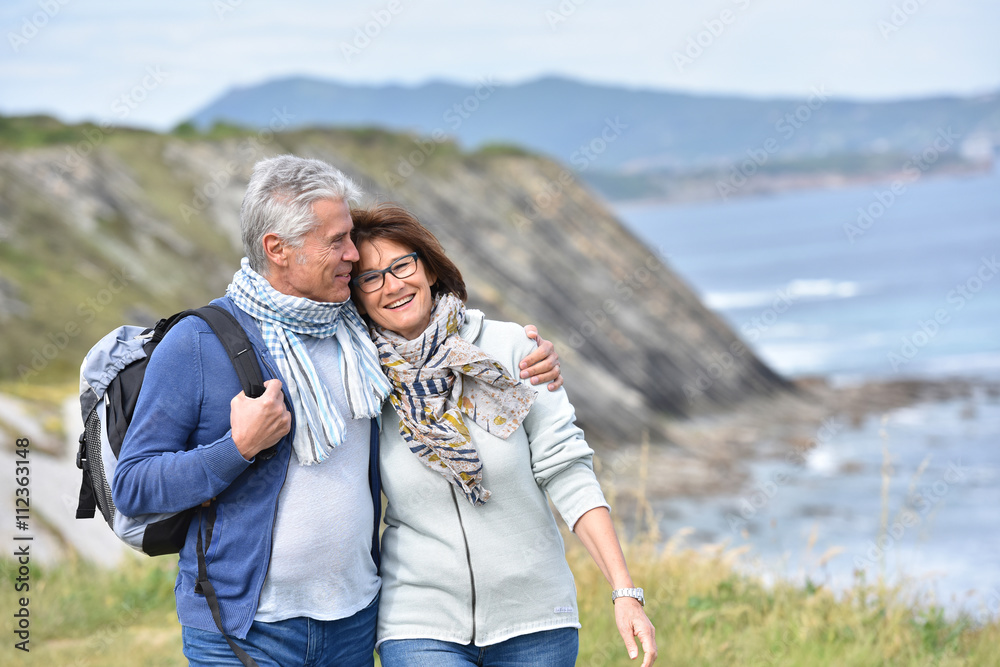 Senior couple walking by sea cliff