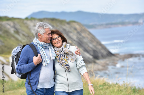 Senior couple walking by sea cliff