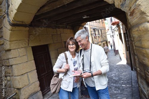 Senior couple of tourists visiting spanish little town