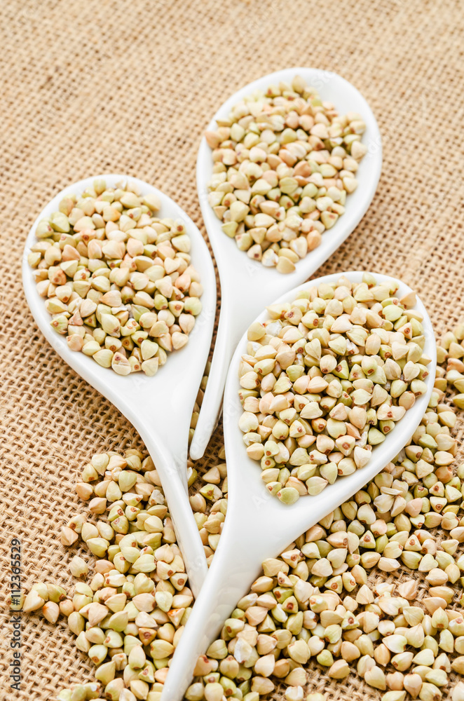 Fototapeta premium Buckwheat groats in white spoons.