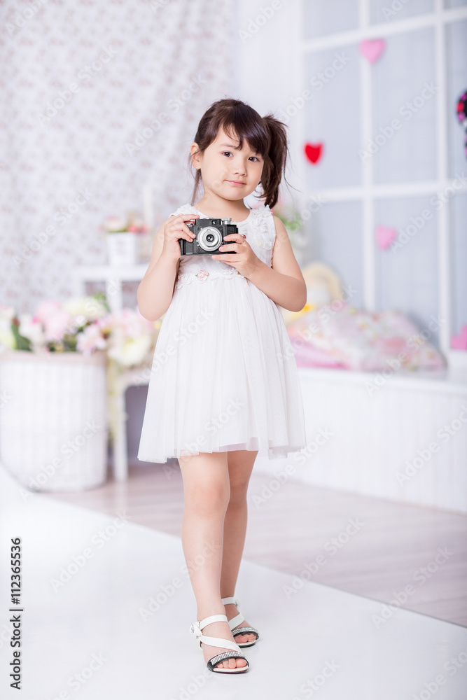 cute little girl holding an old camera. child taking pictures on an old camera cute little girl holding an old camera. child taking pictures on an old camera