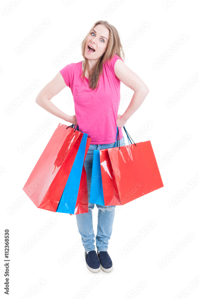 Friendly cheerful girl standing with mouth open and holding bags