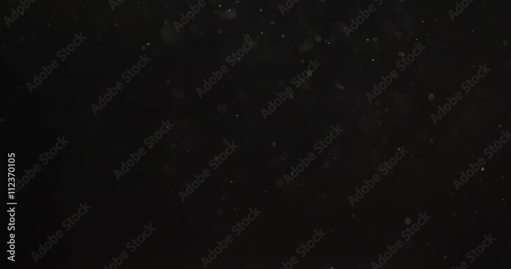 small real dust particles floats over black backgound, 4k prores footage