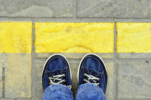 Top View of Male shoes on the asphalt road with yellow line