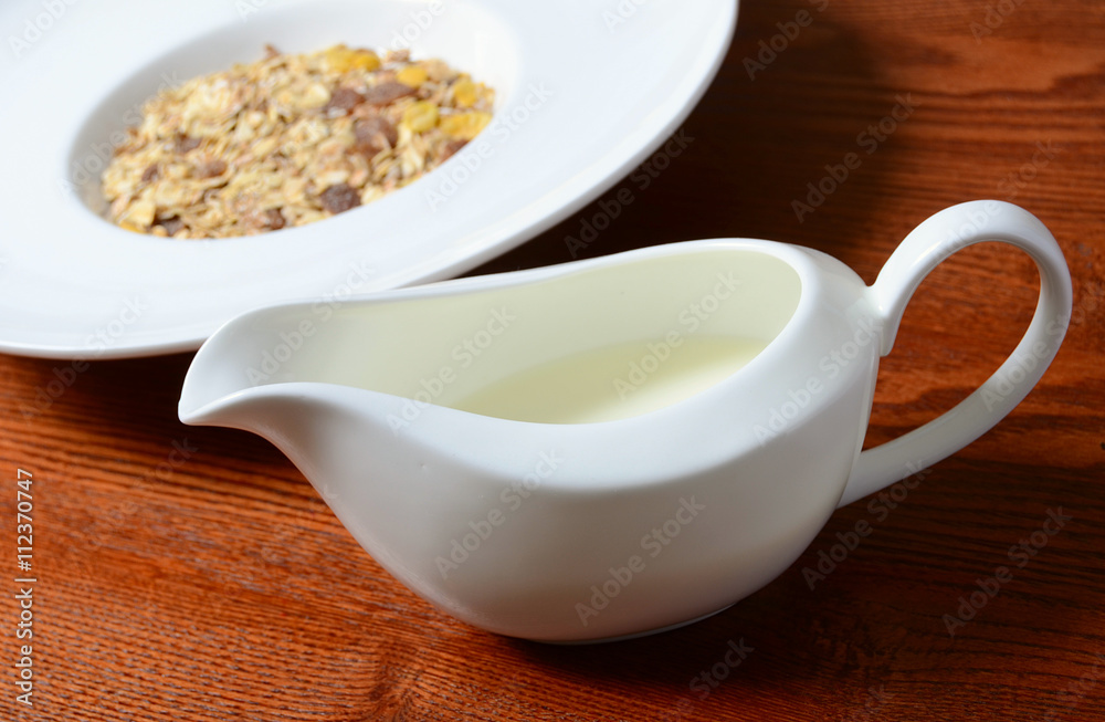 Healthy breakfast background. Bowl of corn flakes with jar of milk on wooden table Healthy breakfast background. Bowl of corn flakes with jar of milk on wooden table