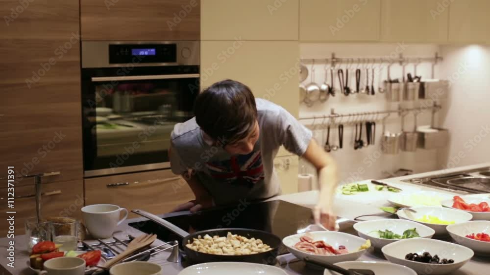 Teenager Boy Clean Electric Stove in the Kitchen Teenager Boy Clean Electric Stove in the Kitchen
