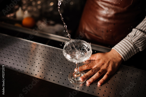 Photography Barman pouring into champagne glass and making a splash
