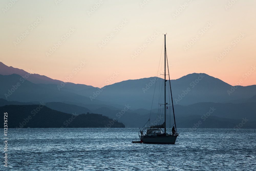 Yacht in sea at sunset