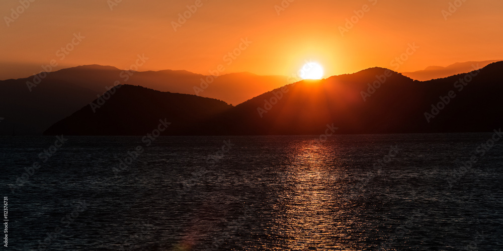 Fototapeta premium Sunset in the mountains by the sea