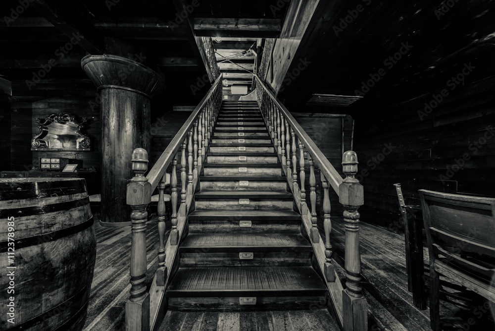 Naklejka premium Drewniane schody. Wnętrze starego statku pirackiego. Czarny i biały