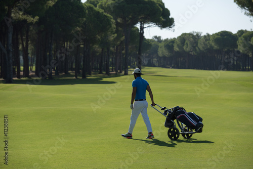 golf player walking with wheel bag