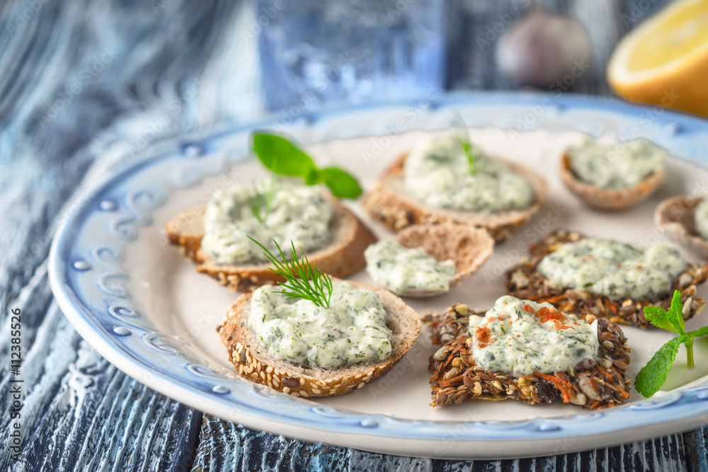 Plate with different bread with tzatziki on the blue table horizontal Plate with different bread with tzatziki on the blue table horizontal