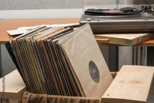 Vinyl record with copy space in front of a collection albums dummy titles, vintage process