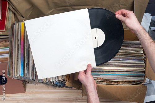Browsing through vinyl records collection. Music background. Copy space. Retro styled image