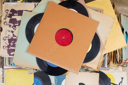 Vinyl record with copy space in front of a collection albums dummy titles, vintage process