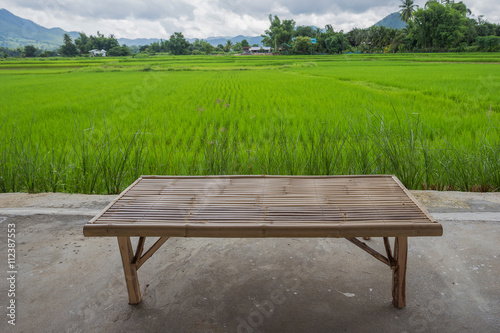 Bamboo bench overlooking fields and beautiful hills.