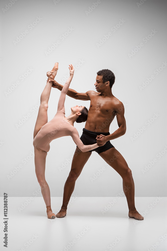 Naklejka premium Couple of ballet dancers posing over gray background