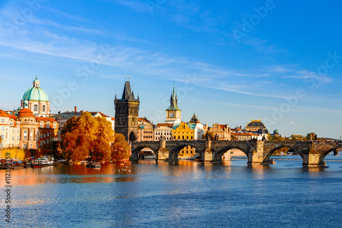 Fototapete View of the Vltava River and Charle bridge with red foliage, Prague, Czech Repub