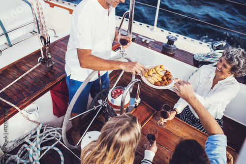 Mixed aged people on the yacht having food and drinks