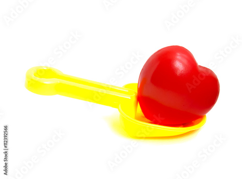 Yellow Spoon beach toys with red heart isolated on white background. Color toys. Beach toys. Isolated toys.Children toys.