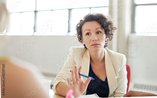 Unposed group of creative business people in an open concept office brainstorming their next project.