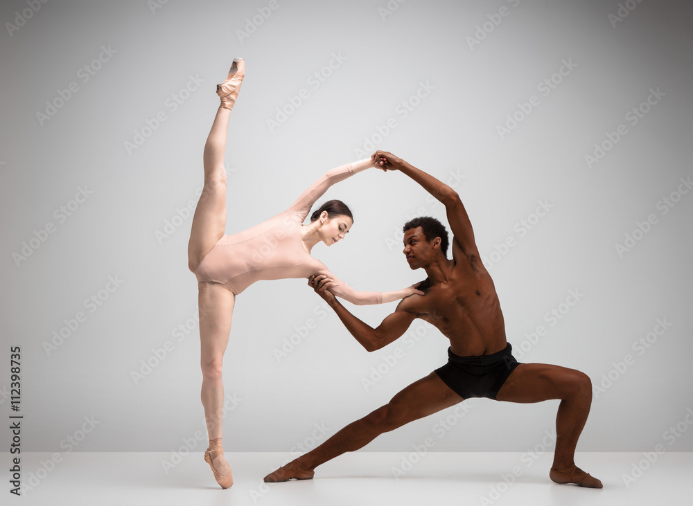 Naklejka premium Couple of ballet dancers posing over gray background