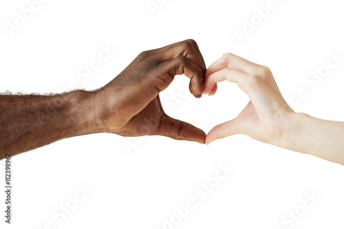 Two people of different races and ethnicities holding hands in the shape of a heart, symbolizing love, peace and unity. African man and Caucasian woman holding hands together. Interracial love concept