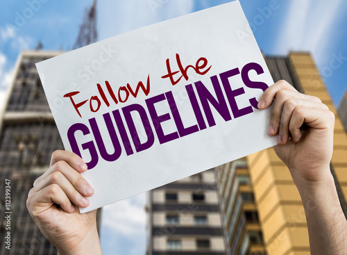 Follow the Guidelines placard with urban background photo