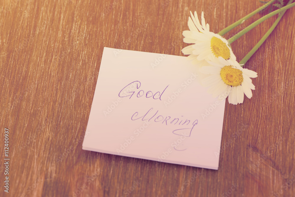 Naklejka premium Daisy flower and piece of paper with text 