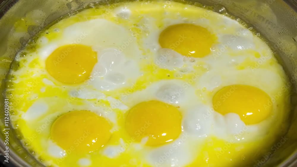 Fresh hens eggs being cracked into a frying pan to make a traditional balanced breakfast Fresh hens eggs being cracked into a frying pan to make a traditional balanced breakfast