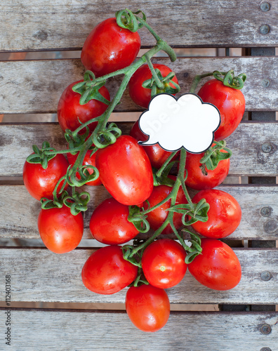 Branch of red ripe cherry tomatoes and label photo