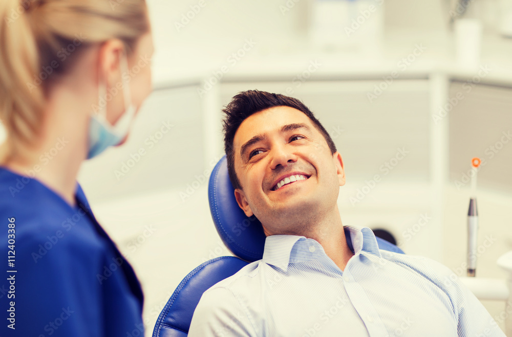 female dentist with happy male patient at clinic female dentist with happy male patient at clinic