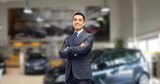 businessman or car dealer over auto show