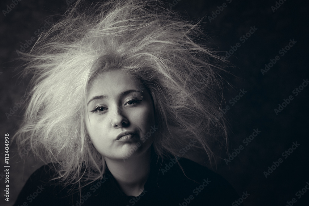 Portrait of annoyed girl with wild hair, photo in black and white. Tired woman with boring face.