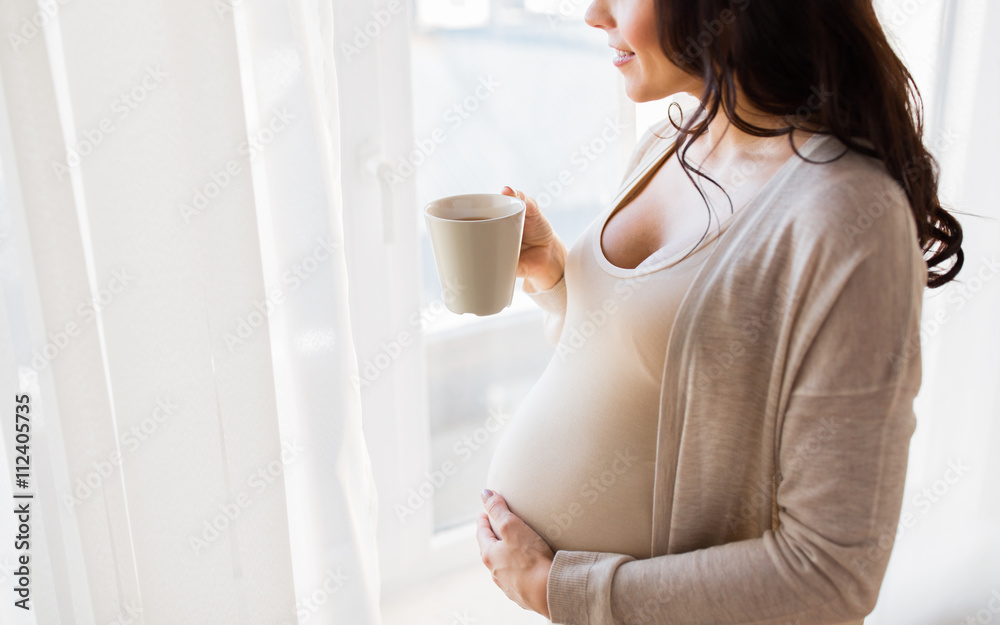 close up of pregnant woman with tea cup at window close up of pregnant woman with tea cup at window