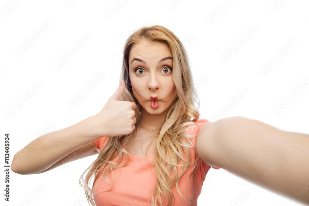 young woman taking selfie and showing thumbs up young woman taking selfie and showing thumbs up
