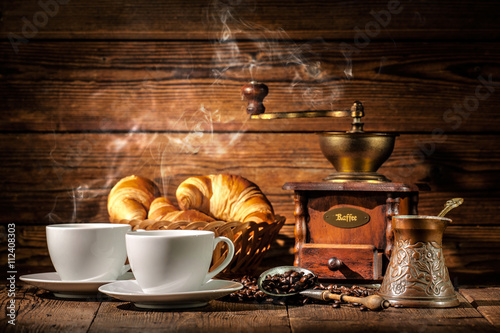 Coffee and croissants on wooden background