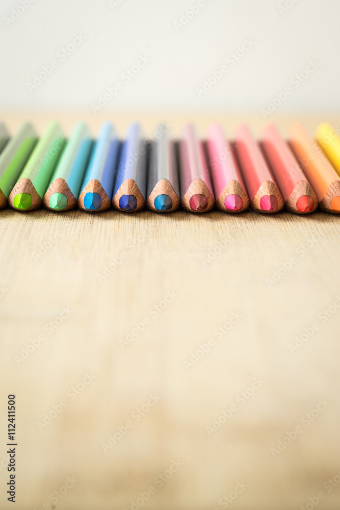 Obraz premium Color Pencils on wood texture. Macro shot of colorful pencils. Vertical view of pencils. Pencils in row.