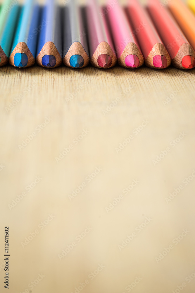 Obraz premium Color Pencils on wood texture. Macro shot of colorful pencils. Vertical view of pencils. Pencils in row.